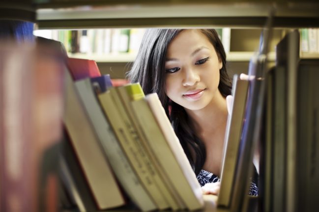 A portrait of an Asian college student in library